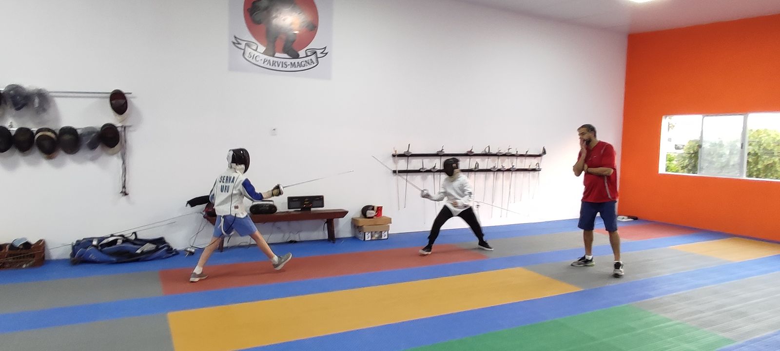 Dos tiradores en un asalto de entrenamiento mientras el maestro observa